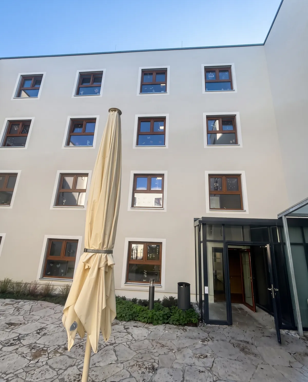 Gepflasterter Weg vor dem Eingang einer Wohnanlage