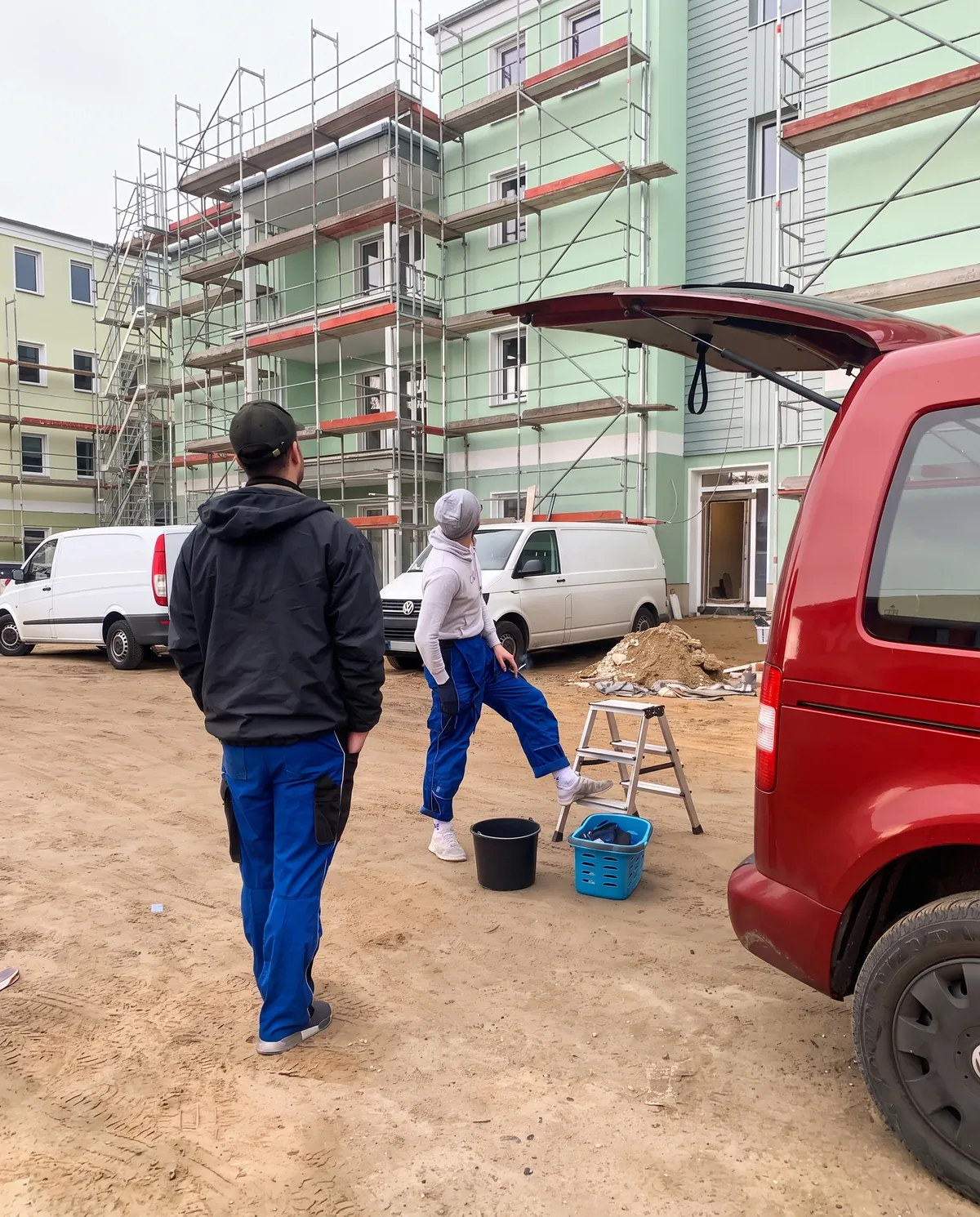 Das SpreeGlanz-Team auf einer Baustelle vor einem eingerüsteten Neubau