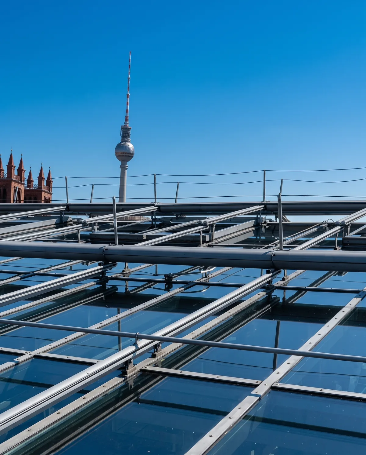 Großes Glasdach mit Stahlkonstruktion, im Hintergrund der Berliner Fernsehturm